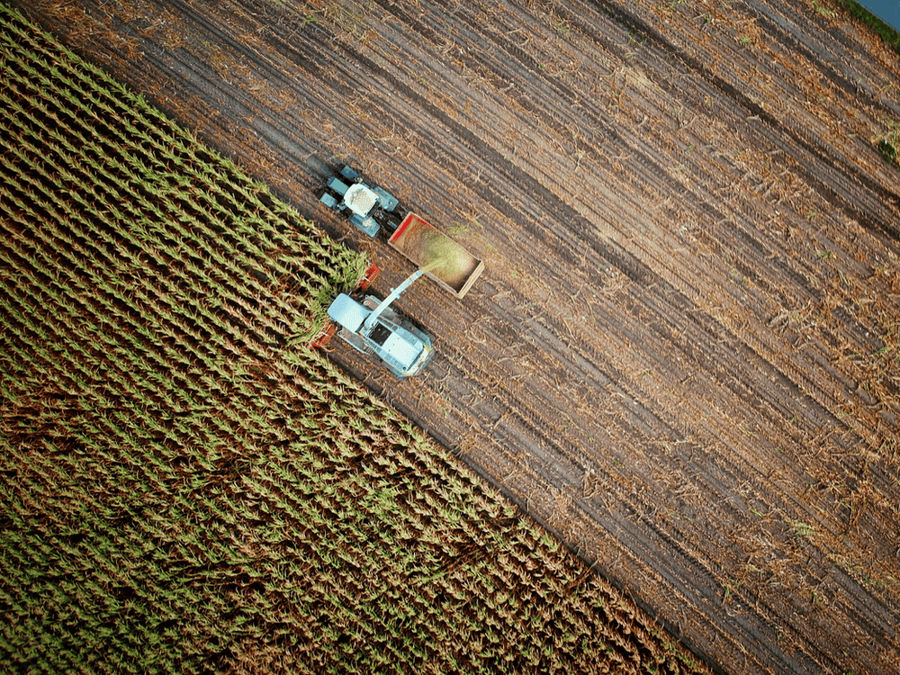 Drone mage of a farmer loading grain from a harvester into a receiving tractor